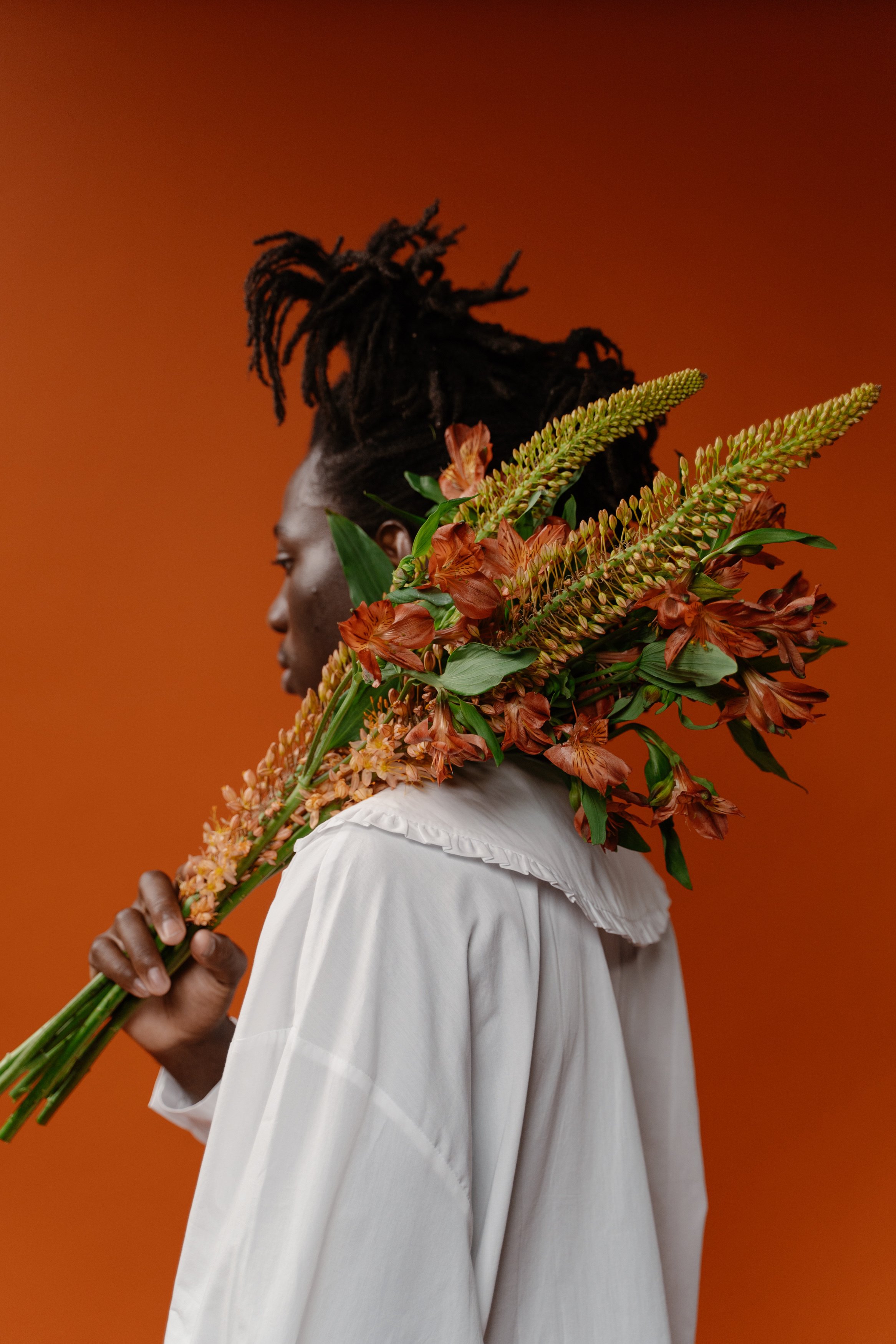 Woman in White Dress Holding Brown and Green Plant